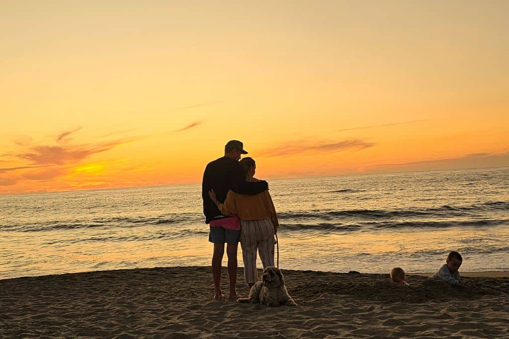 Family on the beach in Mexico safely watching their children playing